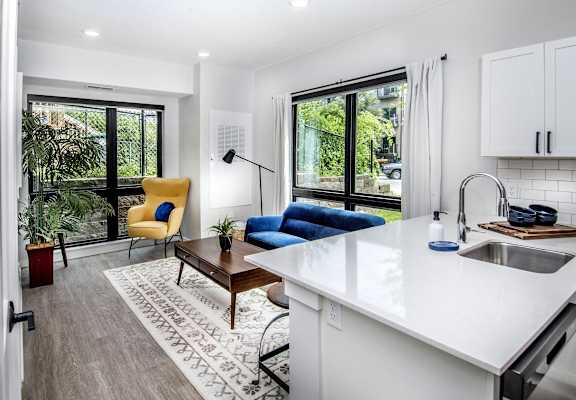 a living room with a couch and a kitchen with a sink