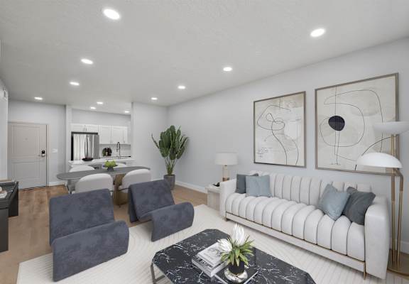 A living room with a white couch, grey chairs, and a coffee table with a plant on it.