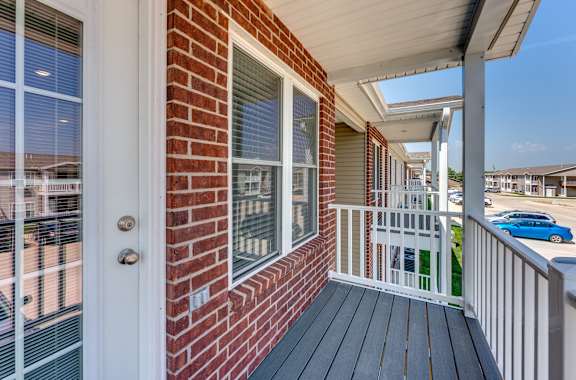 A red brick house with a white door and a white railing.