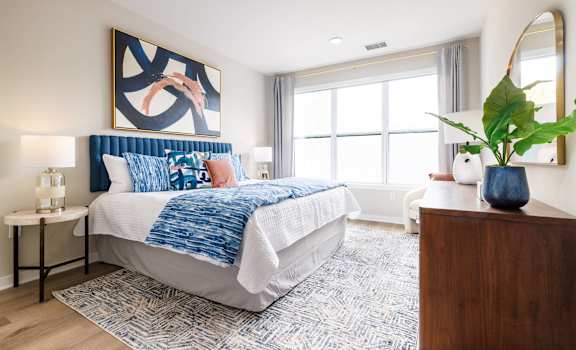 A bedroom with a large bed and a painting on the wall.