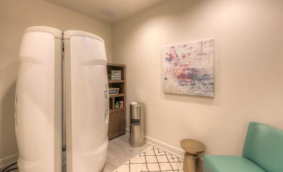 a small living room with a refrigerator and a couch  at Waterside Residences on Quivira, Lenexa