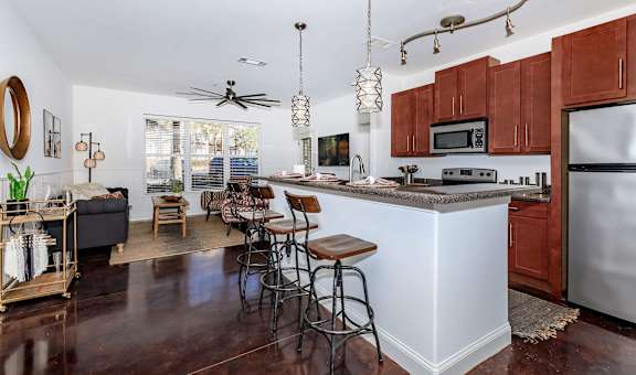A kitchen with a white island and wooden cabinets.