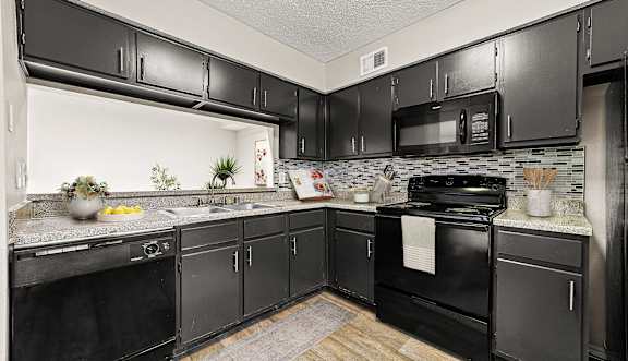 our apartments offer a modern kitchen with black cabinets and stainless steel appliances
