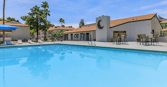 the swimming pool in front of resident clubhouse with moon metal work on chimney  at Tides on McDowell, Phoenix, 85035