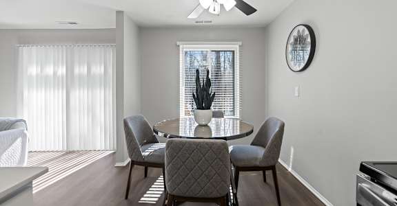A dining room with a table and chairs.