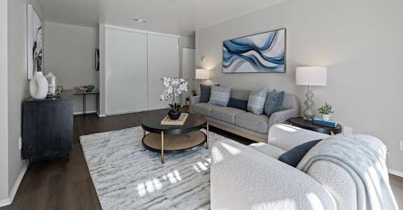 A modern living room with a grey sofa and a coffee table.