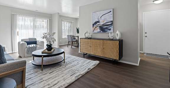 A modern living room with a coffee table, sofa, and a painting on the wall.