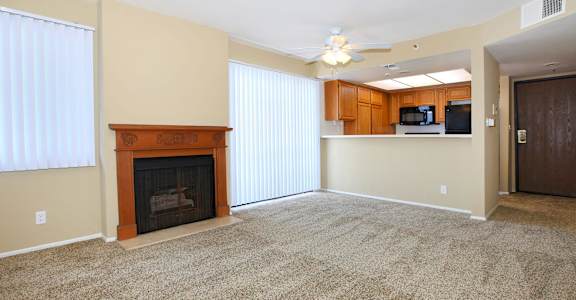 A living room with a fireplace and a ceiling fan.