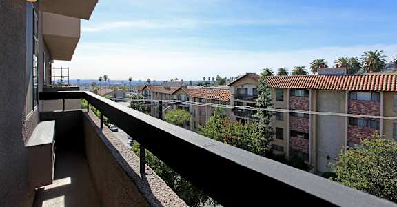 A balcony overlooks a row of apartment buildings.