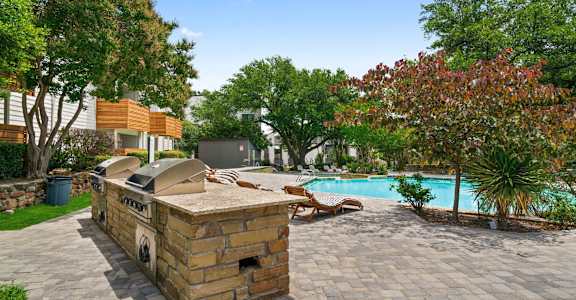 a backyard with a pool and a barbecue grill