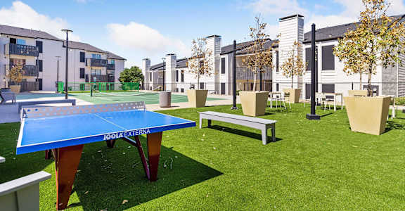 a communal area with a ping pong table and benches