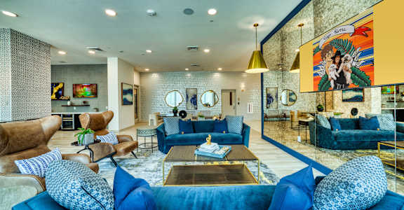 A blue couch with matching cushions is the centerpiece of a modern living room at The Rey Downtown, Phoenix, 85003
