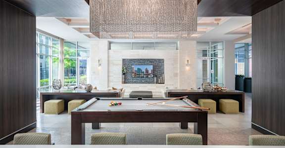 a large living room with a pool table and a fireplace