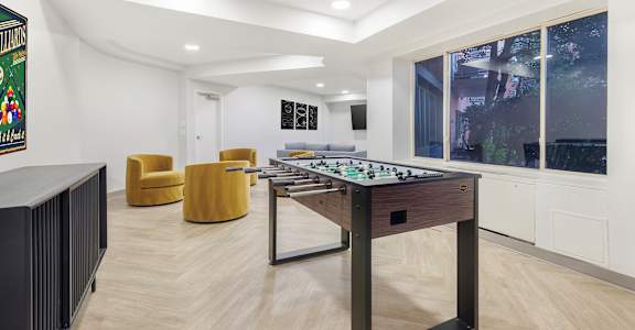 A room with a foosball table and a framed picture on the wall.