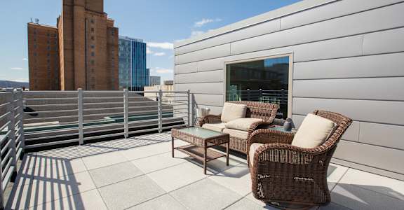 a roof deck with chairs and a view of the city