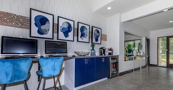 A modern home office with blue chairs and a white wall.at The Keller, San Antonio, TX 78230