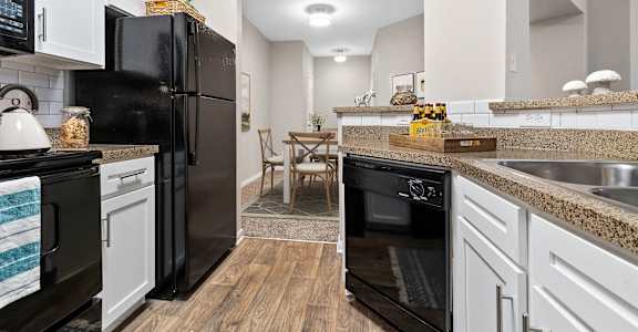 a renovated kitchen with black appliances and white cabinets