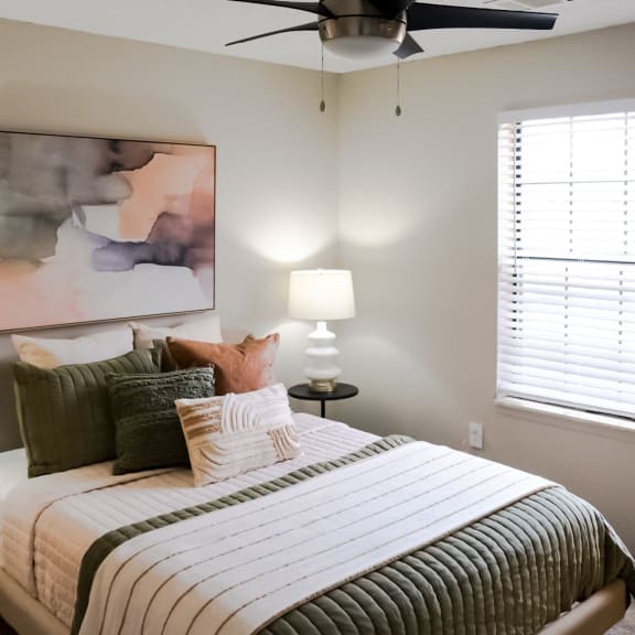 a bedroom with a bed and a ceiling fan