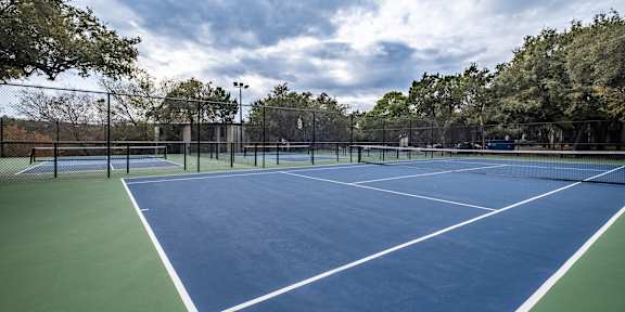 A tennis court with a blue surface and white lines.