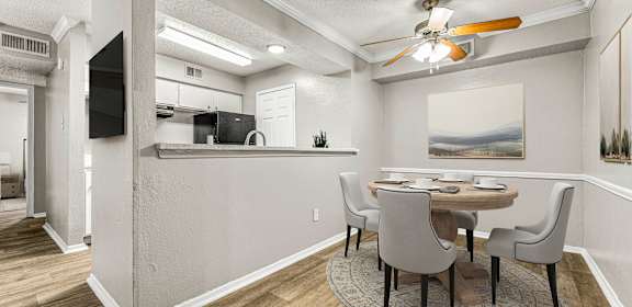 a dining room with a table and chairs and a ceiling fan  at 5636 Apartment Homes, Texas, 75254