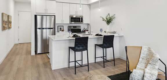 an open kitchen with a large island with two bar stools