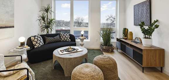 a living room with a couch and a coffee table and large windows