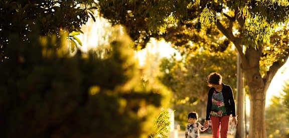 a mother and child walking down a sidewalk