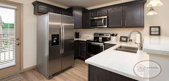 an updated kitchen with stainless steel appliances and white countertops