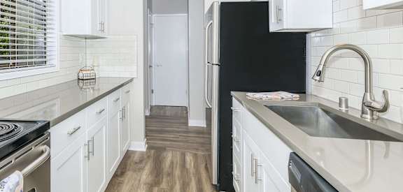 a kitchen with white cabinets and a black refrigerator