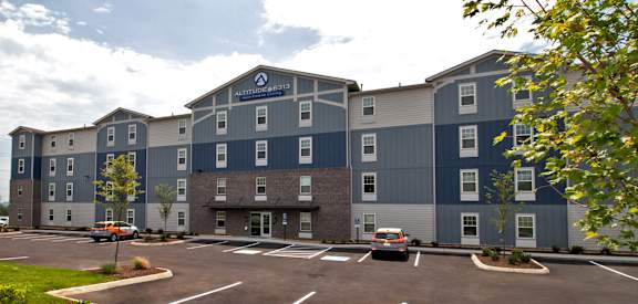 A large building with a parking lot in front of it.