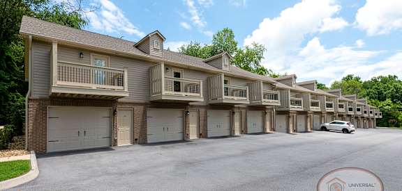 A row of townhouses with a car parked in front.
