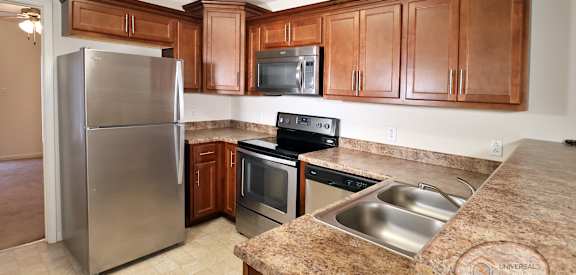 A kitchen with a granite counter top and stainless steel appliances.