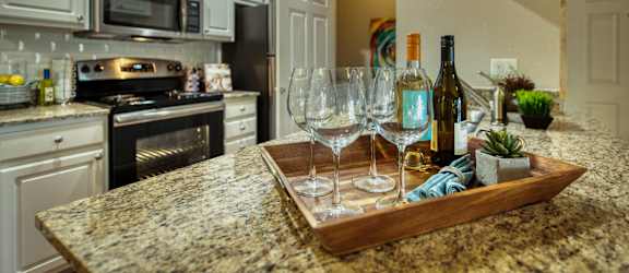 a kitchen with a granite counter top with wine glasses on it