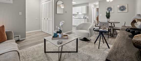 A modern living room with a grey carpet and white walls.
