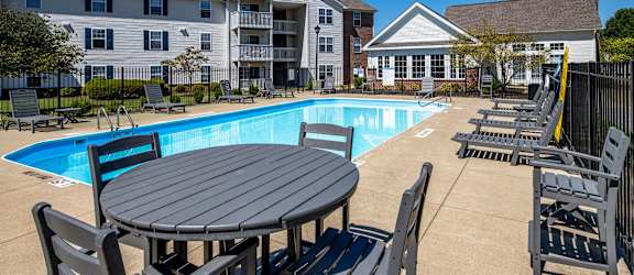 our apartments offer a swimming pool with a table and chairs