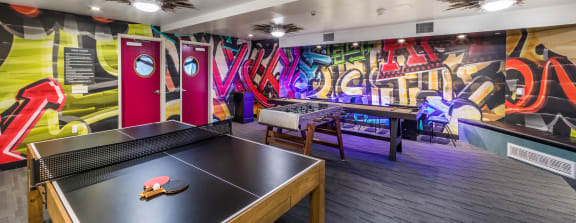 Apartment complex game room with table tennis and and foosball table