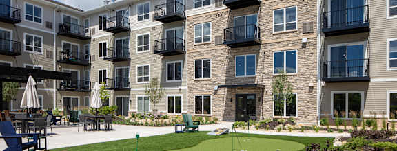 an artificial turf putting green in front of an apartment building