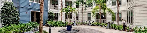 A courtyard with a circular walkway and a fountain in the middle. at CODA Apartments , Orlando, FL, 32826