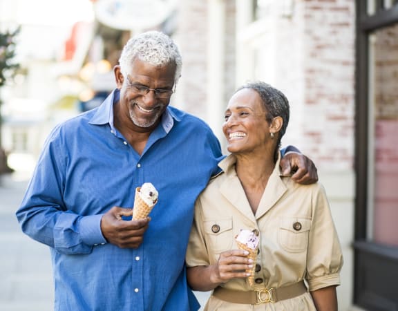an older man and woman eating ice cream together