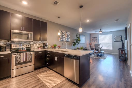 a kitchen with dark cabinets and stainless steel appliances  at EdgeWater at City Center, Lenexa, KS, 66219