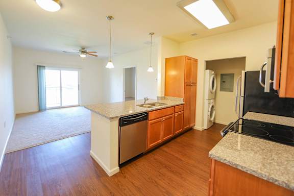 A kitchen with wooden cabinets and a granite countertop.