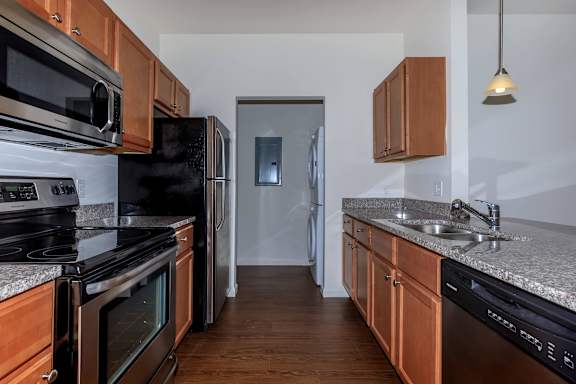A kitchen with wooden cabinets and black appliances.