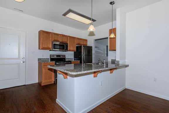 A kitchen with a white island and wooden cabinets.