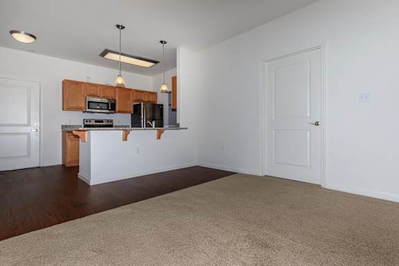 A kitchen with white walls and wooden cabinets.