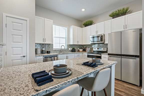 an open kitchen with granite counter tops and stainless steel appliances