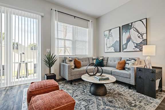 a living room with a couch and a chair and a window