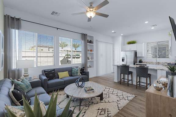 A living room with a grey couch and a round table.