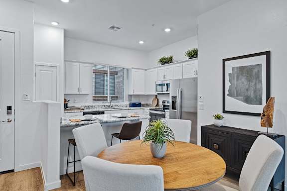 A modern kitchen with a dining table and chairs.