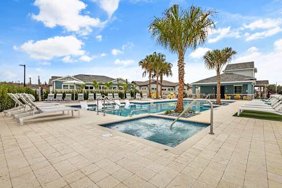 a swimming pool with palm trees and lounge chairs around it