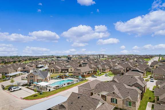 an aerial view of a suburb of houses with a swimming pool